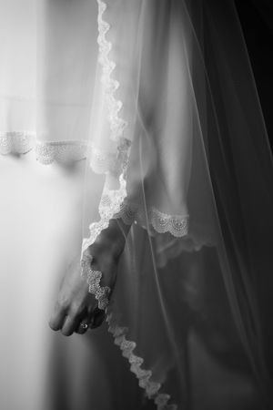 Delicate lace details of a wedding veil flow elegantly in black and white.