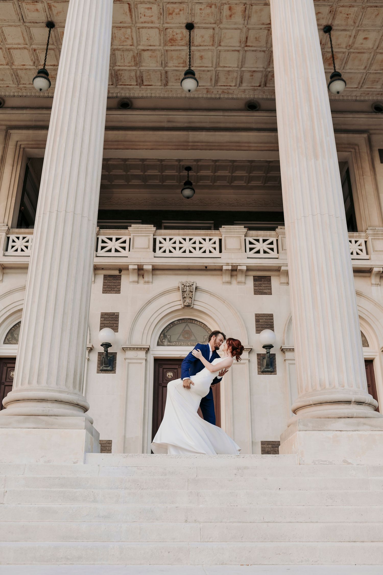Romantic engagement photos with sunlight between city buildings