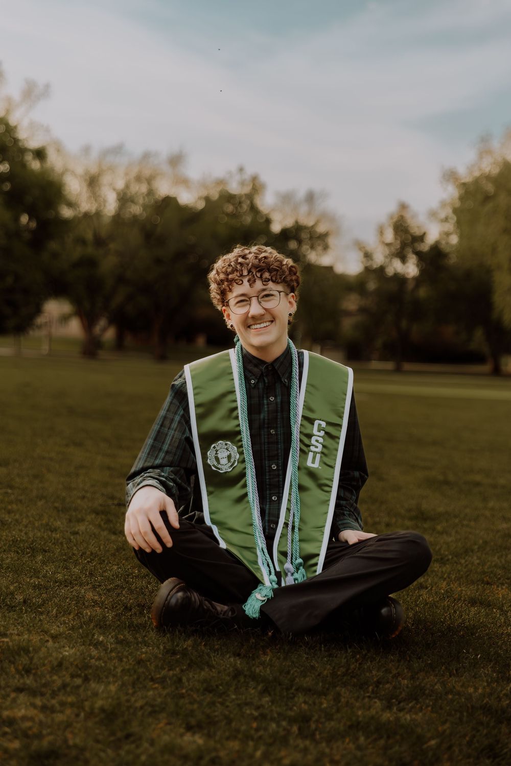 Boy sits and poses for graduation photos at CSU (Colorado State University) graduation photos in Fort Collins, Colorado