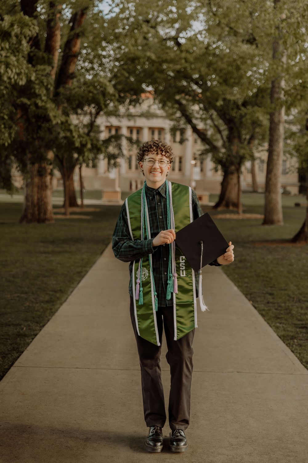 Boy stands and poses for graduation photos at CSU (Colorado State University) graduation photos in Fort Collins, Colorado