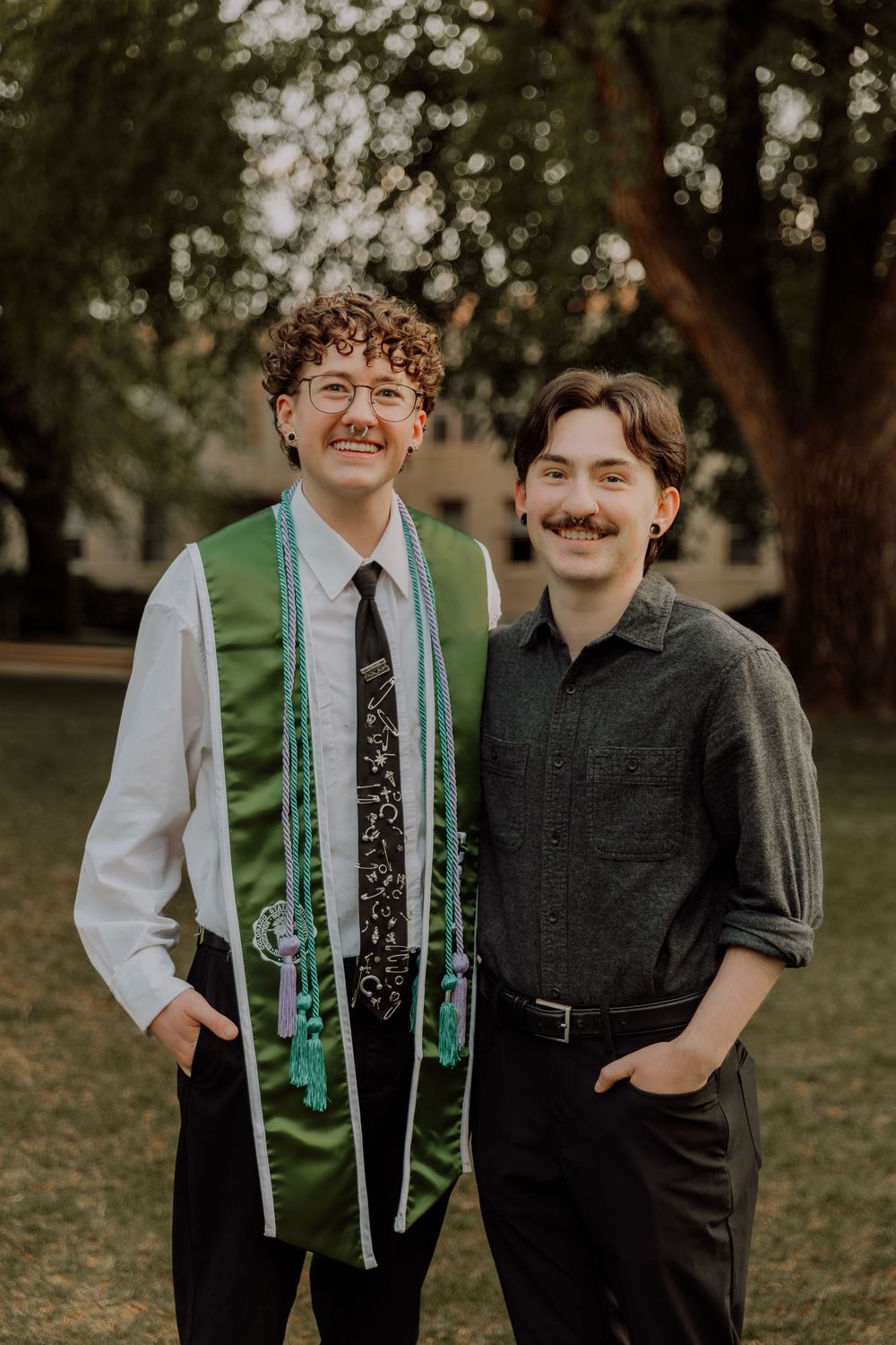 Boy stands and poses with friend for graduation photos at CSU (Colorado State University) graduation photos in Fort Collins, Colorado