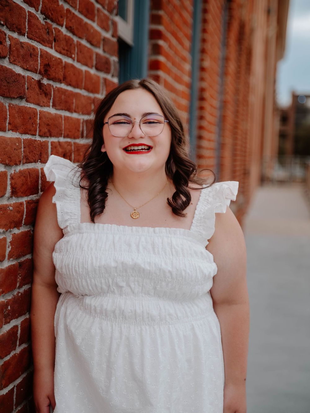 Girl stands, leans on wall, and poses for senior photos, cinematic, urban, and portrait photos in Denver, Colorado outside and in nature