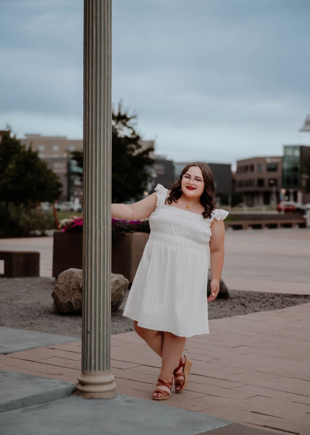 Girl swings on pole and poses for senior photos, cinematic, urban, and portrait photos in Denver, Colorado outside and in nature