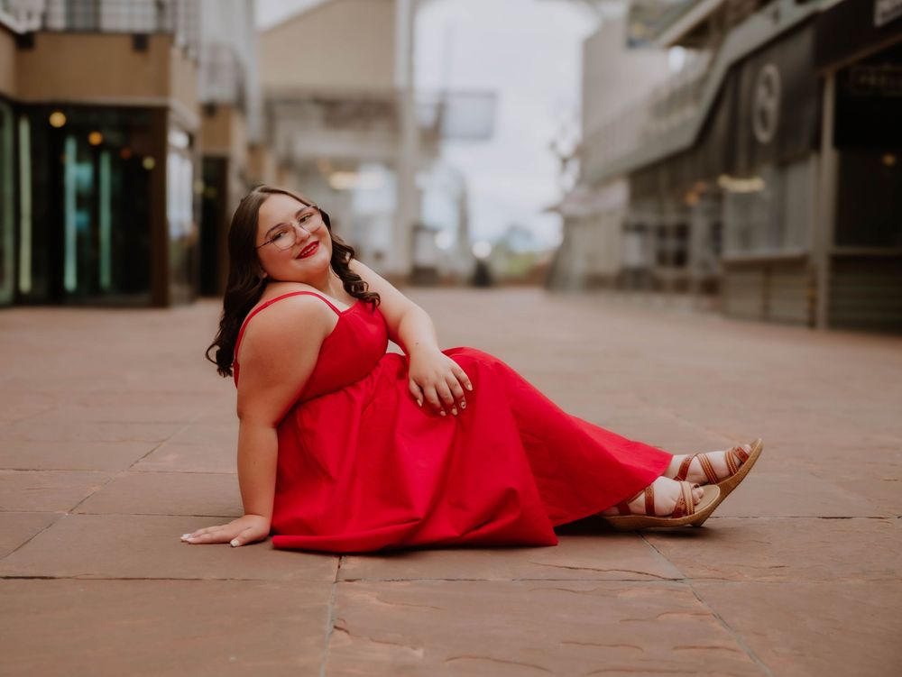 Girl sits and poses for senior photos, cinematic, urban, and portrait photos in Denver, Colorado outside and in nature