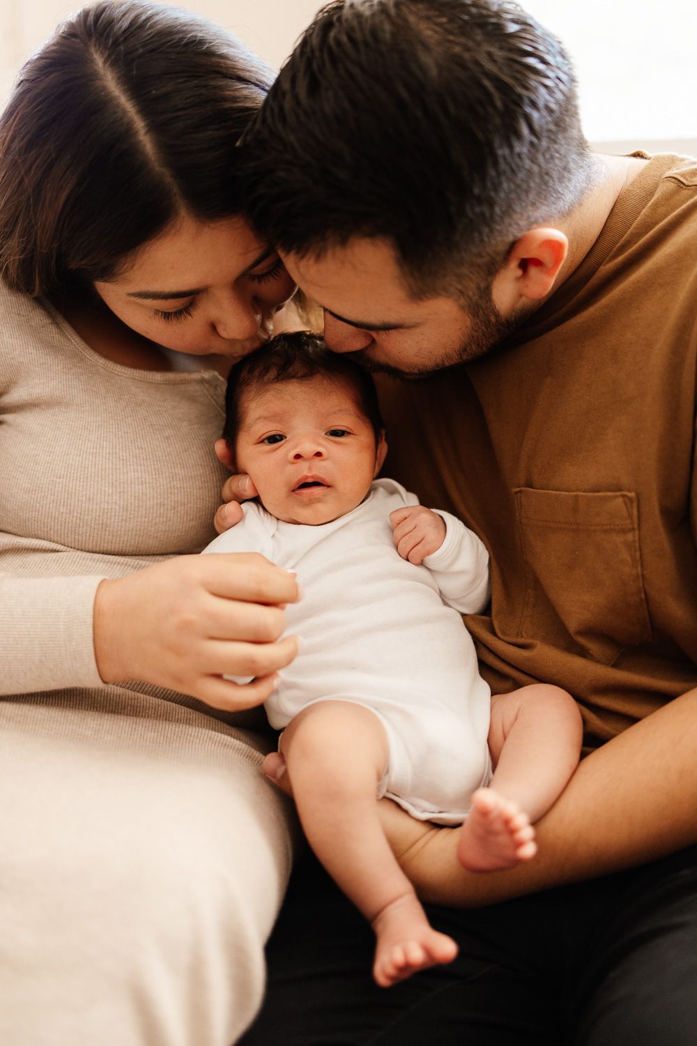 Mom and dad kiss their baby at newborn session with Bay Area Newborn Photographer Cindy Tucey in Campbell