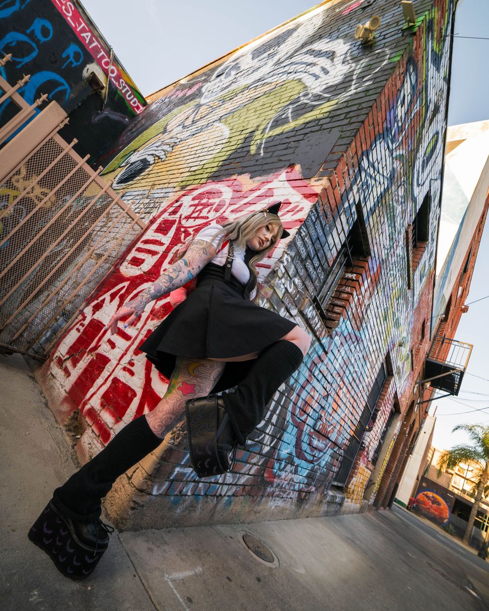 Model in cat ears and platform boots poses in front of a graffiti wall in Santa Ana, captured by Chris Cornish Photography.