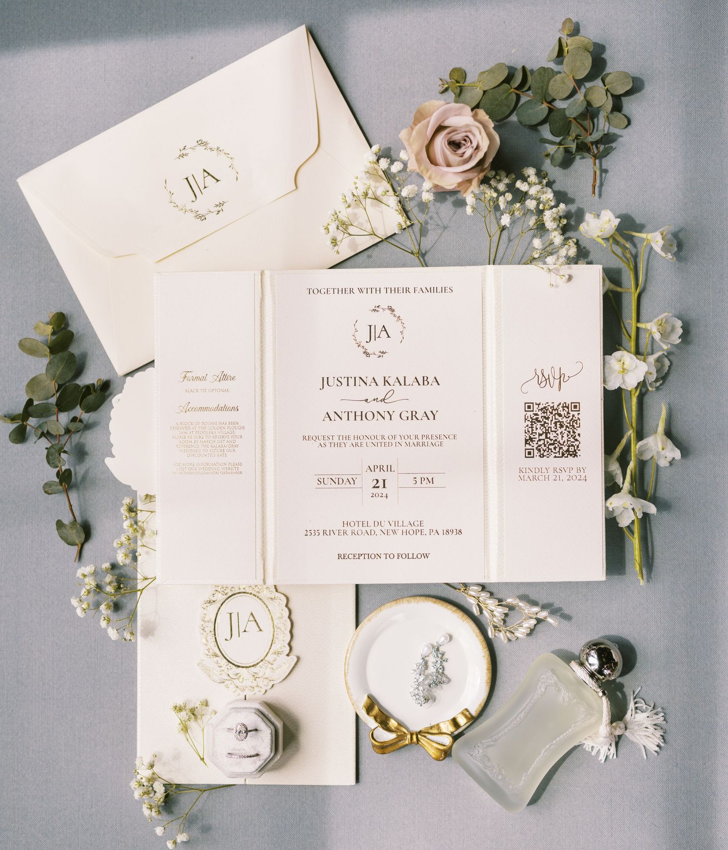 Elegant wedding invitation suite for Justina Kalaba and Anthony Gray with floral accents and QR code on gray backdrop.