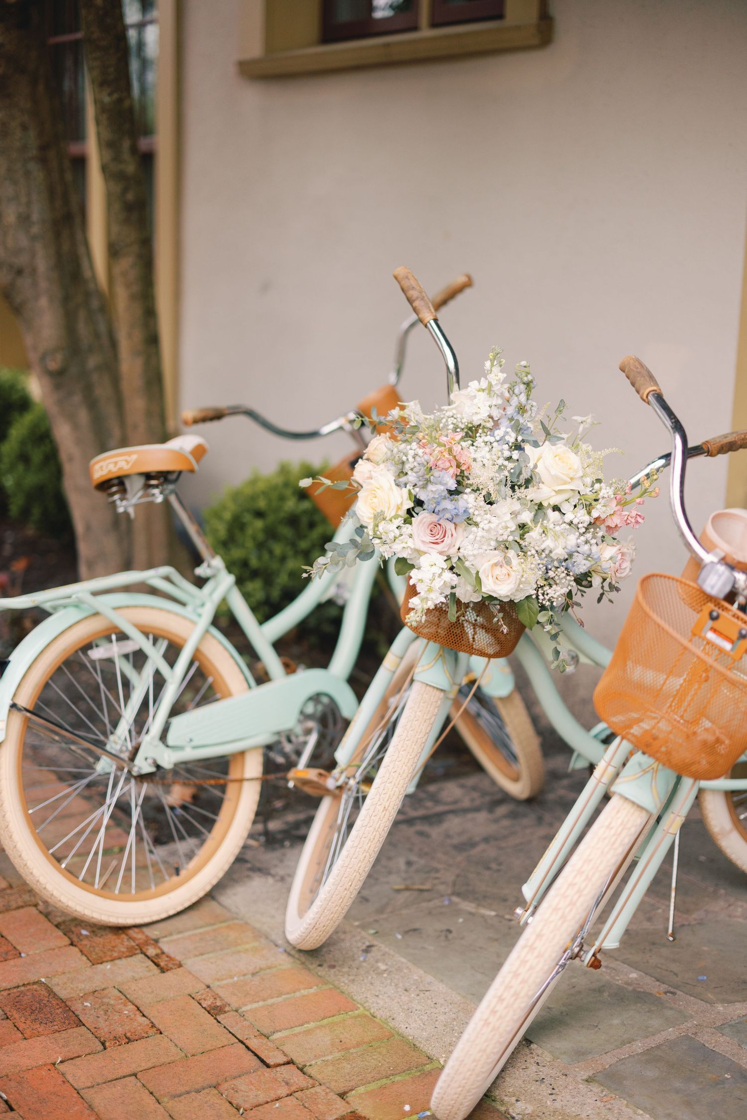 Vintage mint and white cruiser bicycles decorated with a romantic pastel floral bouquet arrangement.