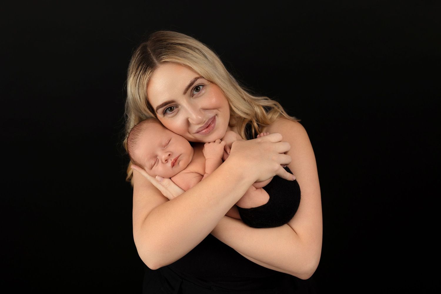 Professional studio portrait on black background.