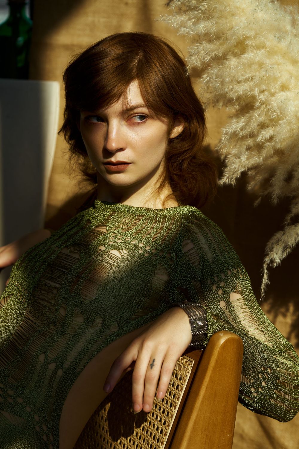 Artistic portrait featuring model in green textured dress with dramatic lighting.