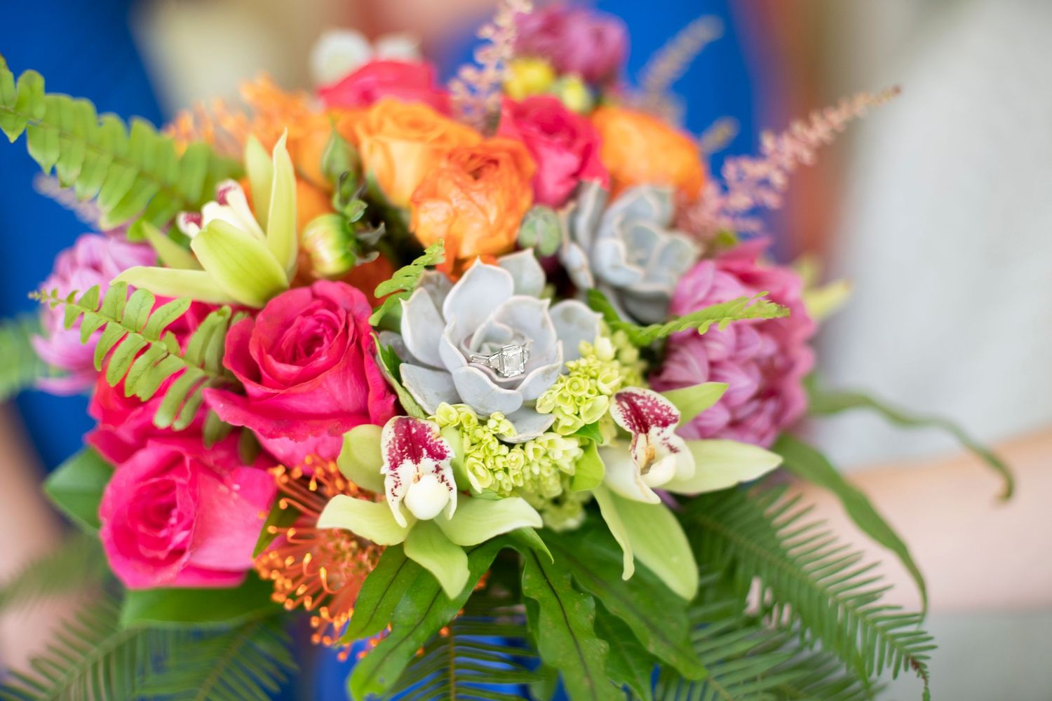 Vibrant bridal bouquet with pink roses, orange blooms, succulents, and green ferns. Gasparilla Inn
