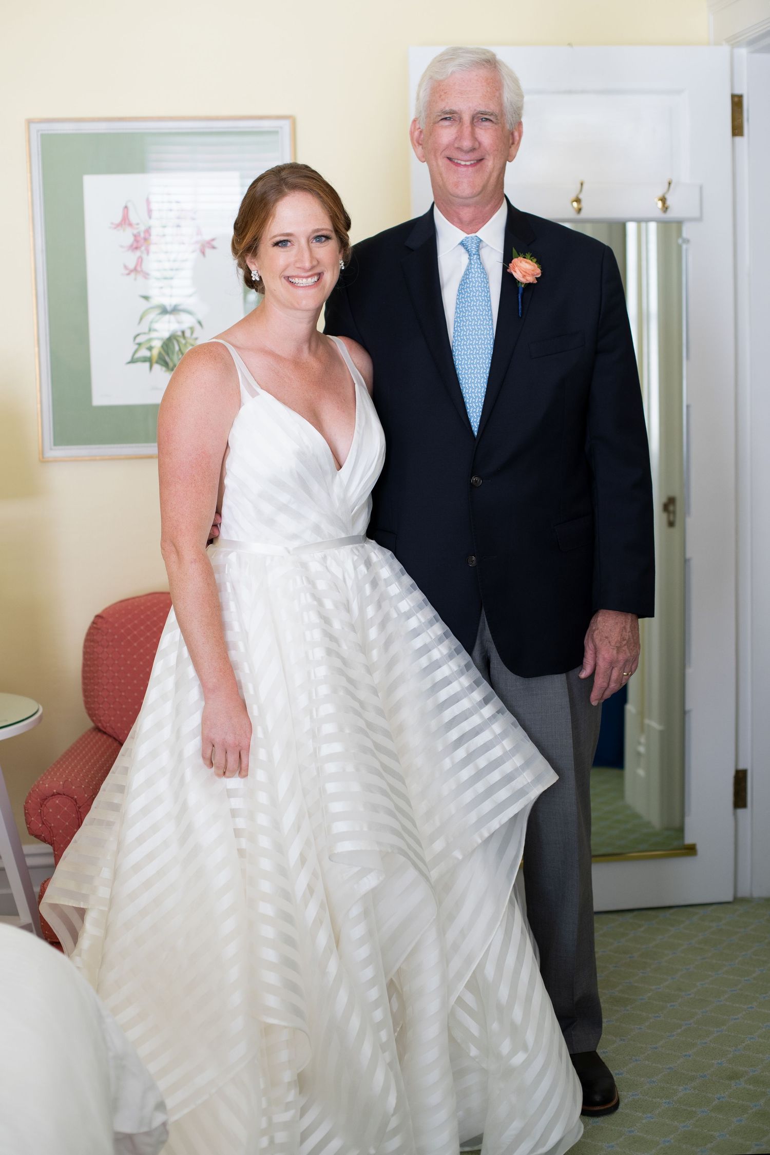 Smiling bride in striped white wedding gown poses with tall man in navy suit indoors. Gasparilla Inn