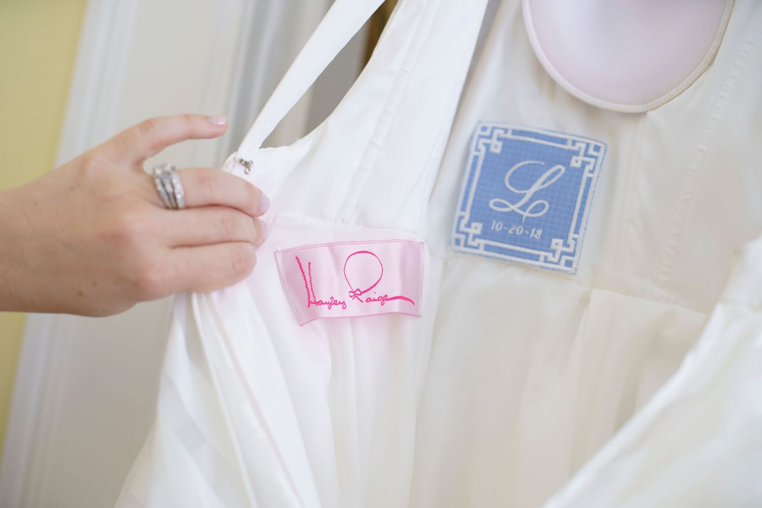 Close-up of white wedding dress label with monogrammed blue tag detail. Gasparilla Inn