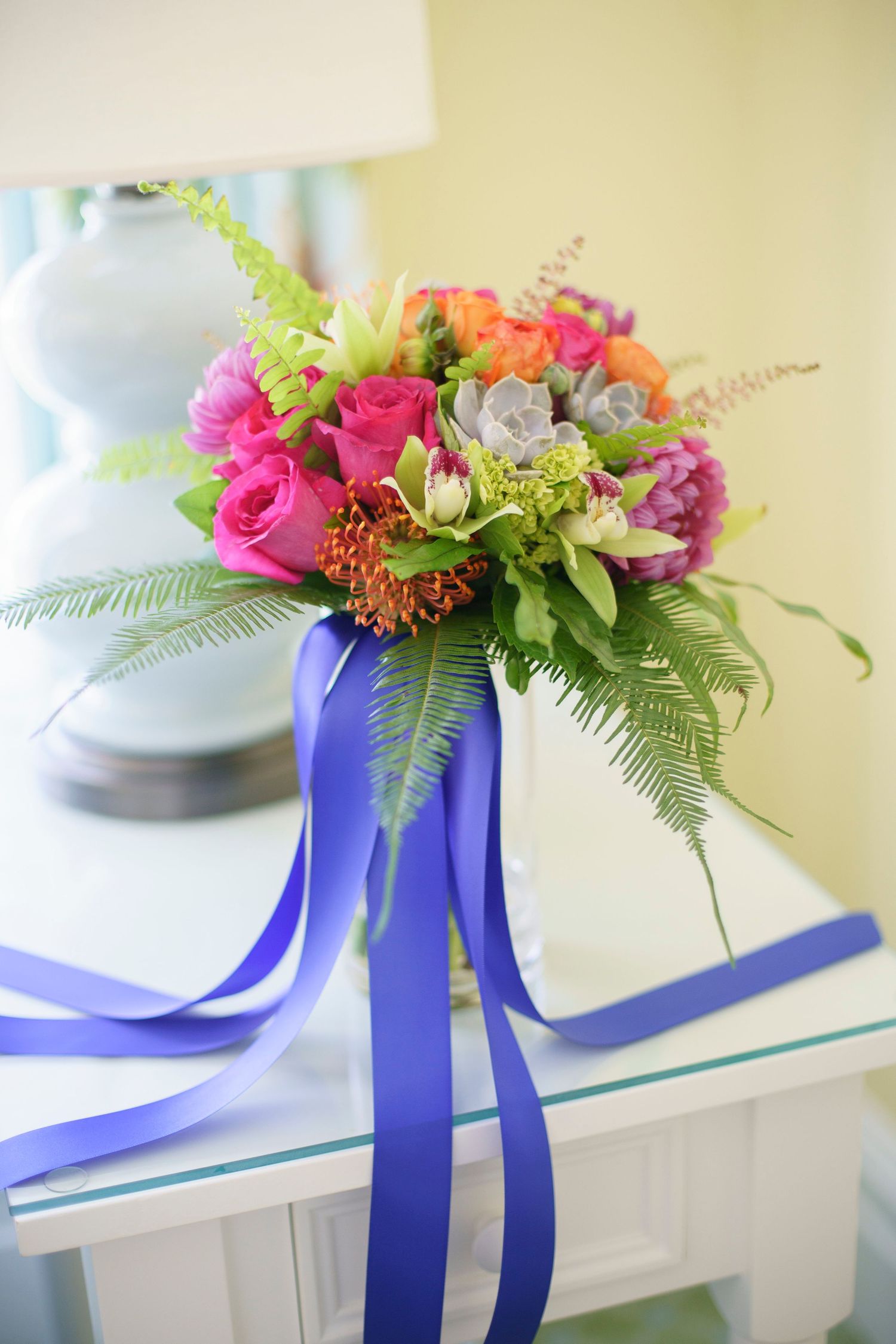 Colorful bridal bouquet with pink roses and succulents tied with royal blue ribbon. Gasparilla Inn