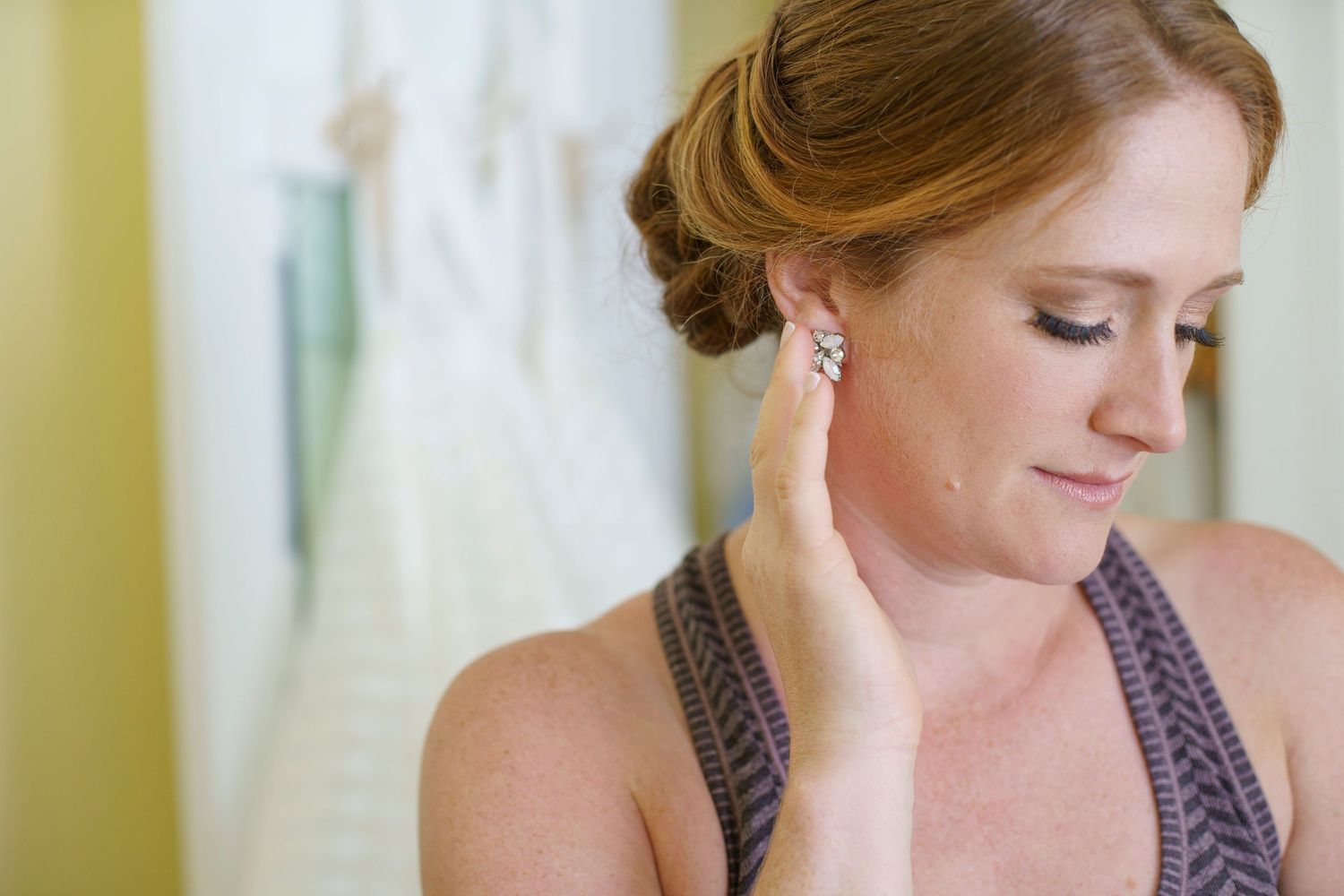 Bride with updo hairstyle touches elegant crystal earring while getting ready. Gasparilla Inn
