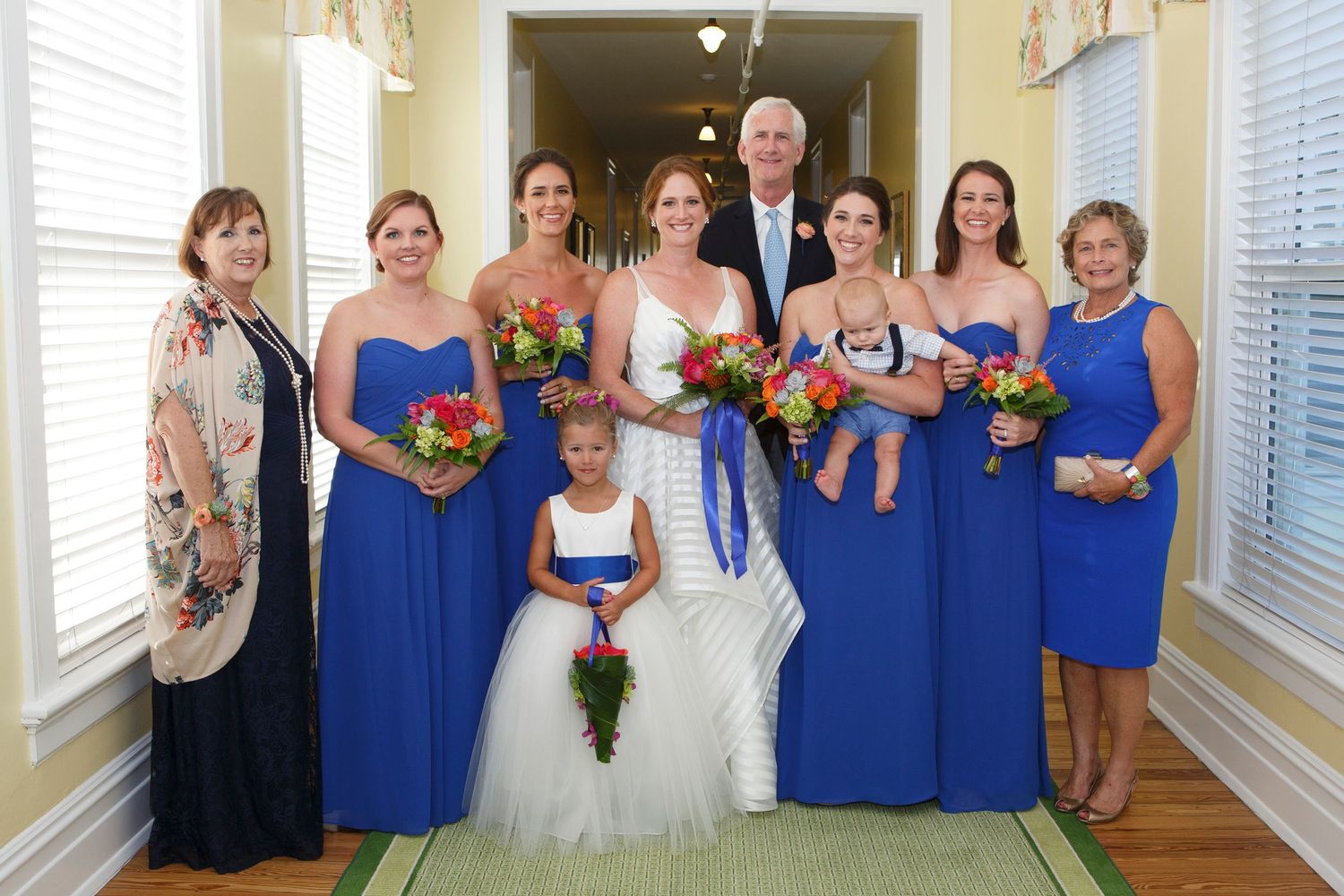 Wedding party group portrait with bridesmaids in royal blue dresses and family members. Gasparilla Inn