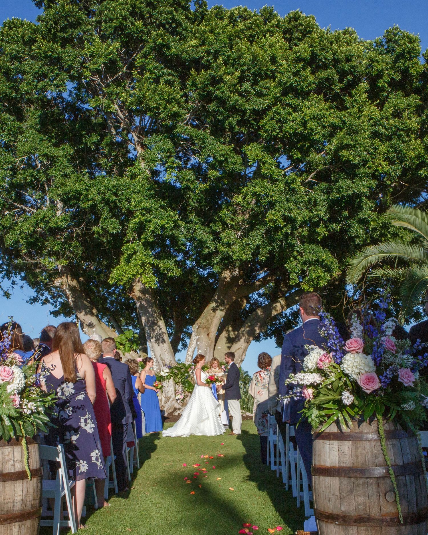 Gasparilla Inn, Outdoor wedding ceremony under large tree with guests seated along flower-lined aisle. Gasparilla Inn