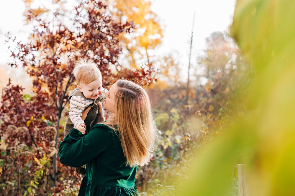 Golden sunset light illuminates autumn trees during outdoor photoshoot.