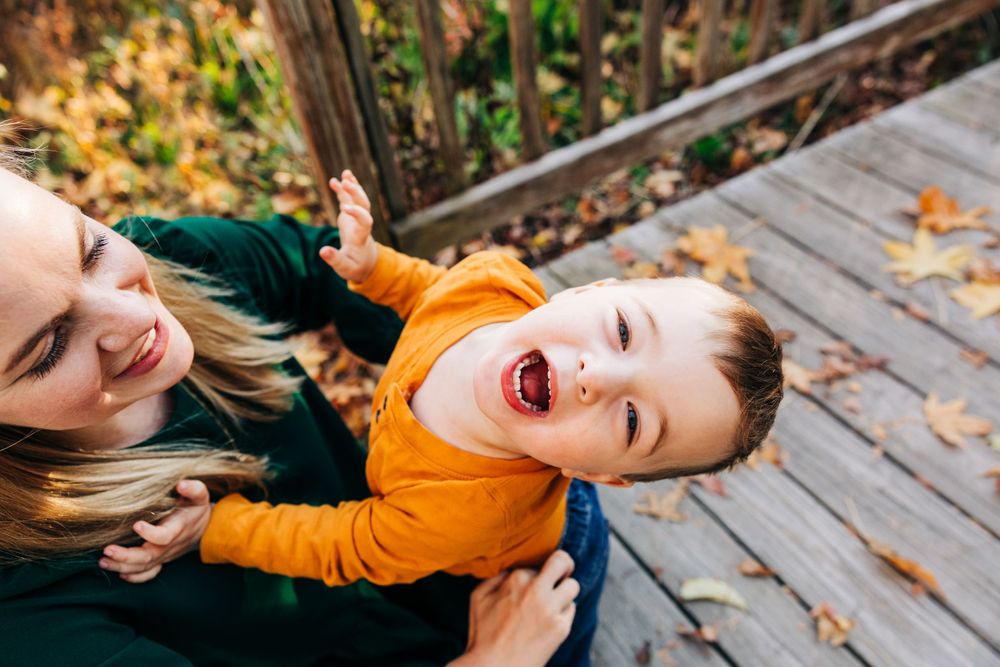 Playful moments captured on rustic wooden boardwalk during autumn.