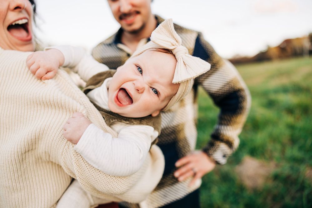 Playful family moments captured in natural outdoor setting.