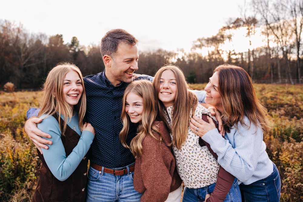 Candid family moments captured during golden hour in an autumn field.