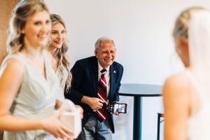 A candid moment of laughter shared during wedding preparations in a bright indoor setting.