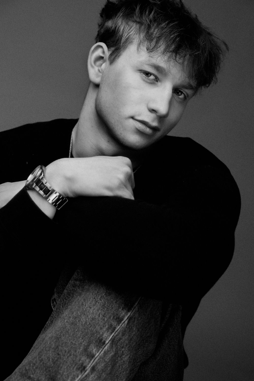 Black and white fashion portrait series showing dramatic angles and shadows against a dark background.