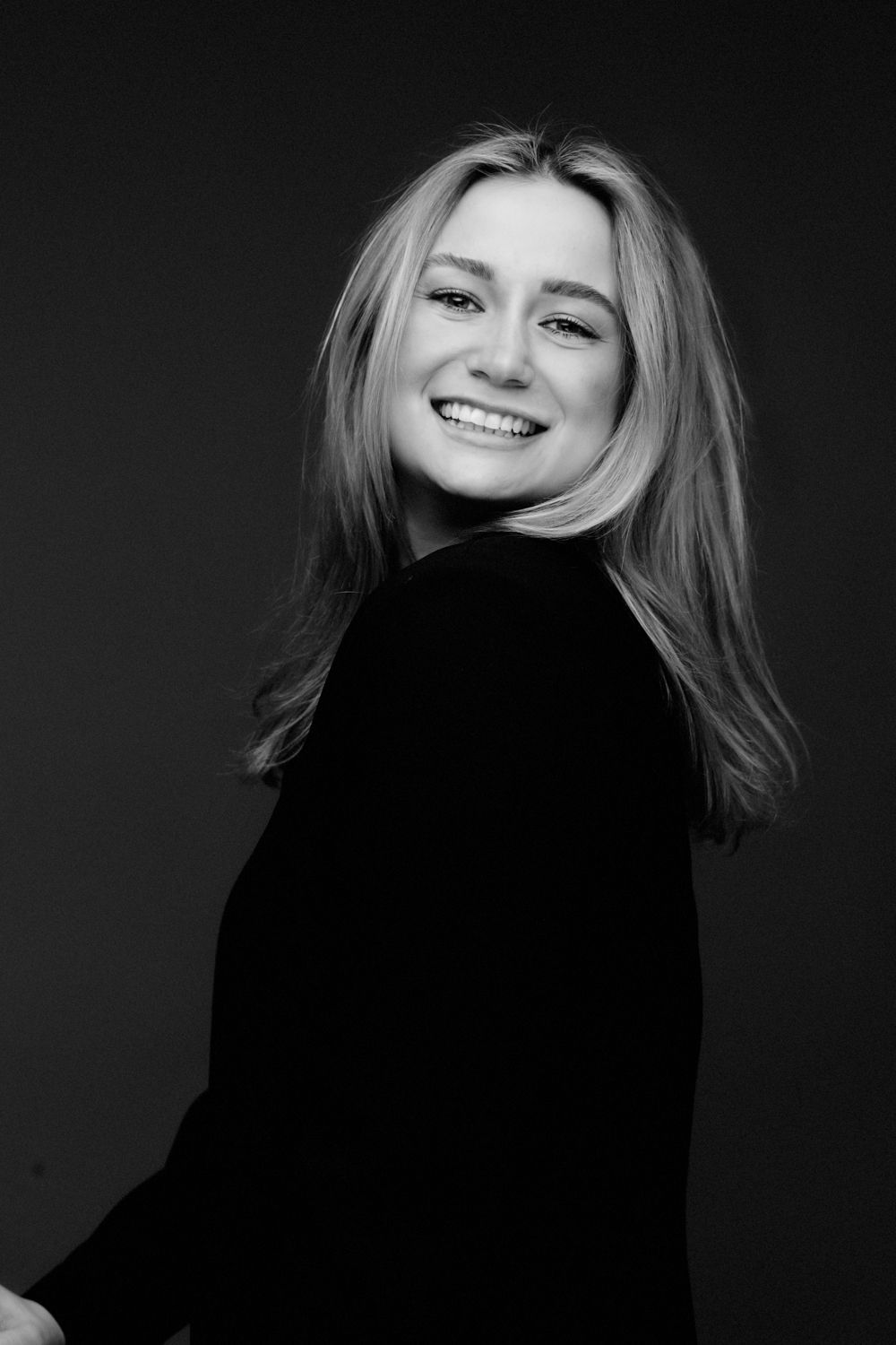 Monochromatic studio portraits featuring blonde hair and black clothing with expressive poses against dark backdrop.