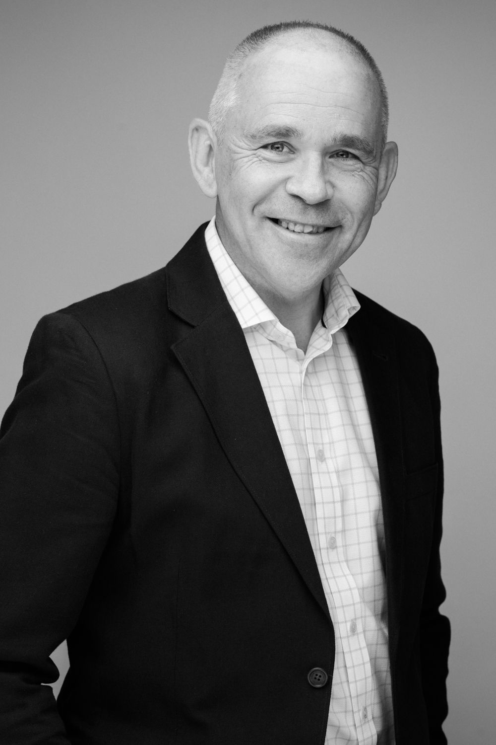 Professional black and white headshot series showing a person in business attire against a light background.