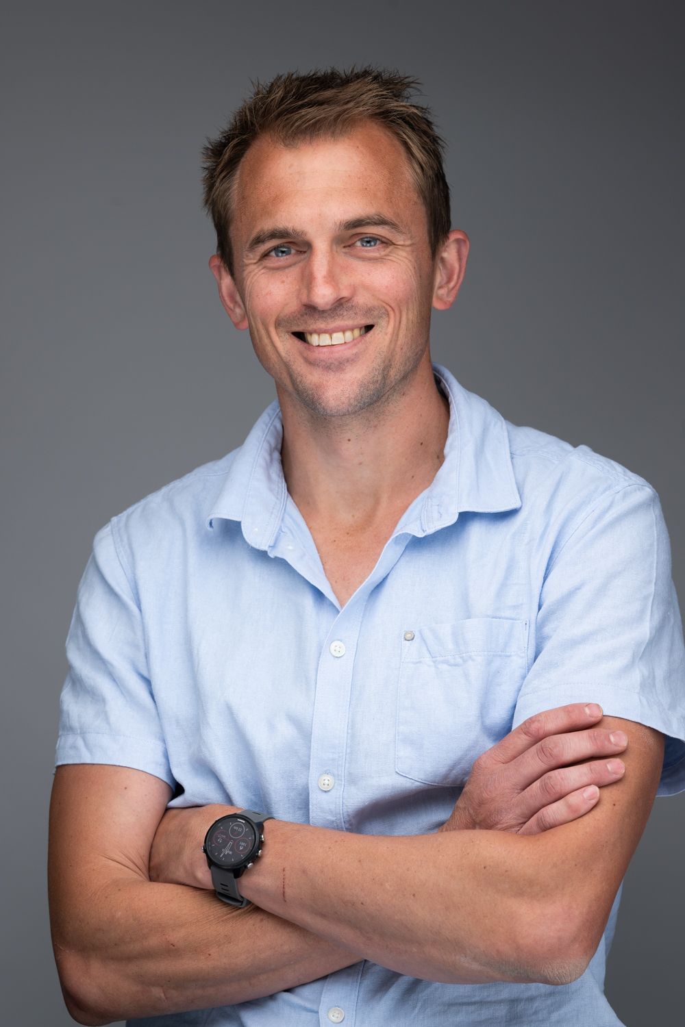 Professional studio portrait series showing a person in a light blue shirt against a gray background with various poses.