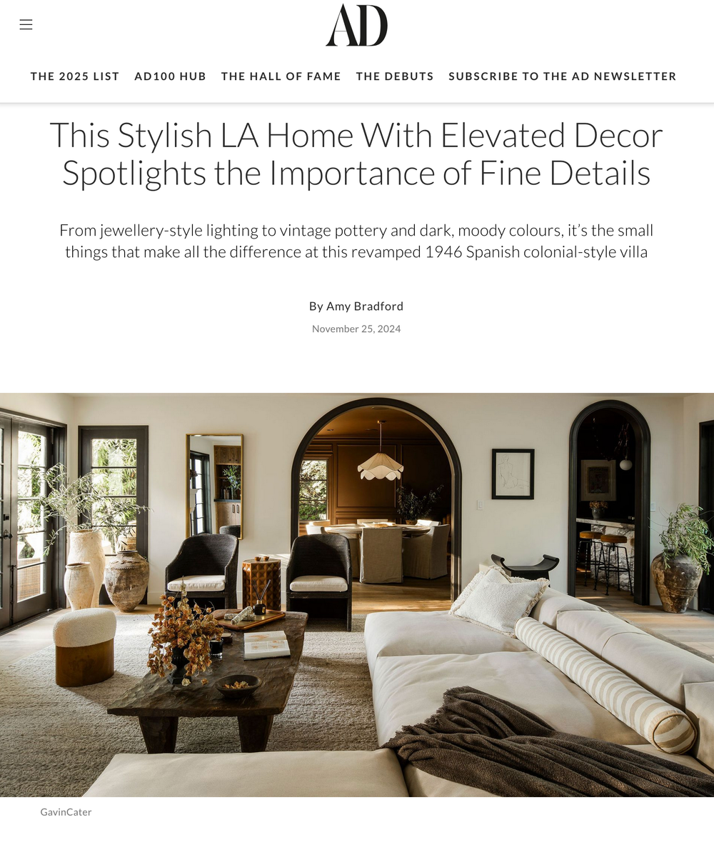 Modern LA living room with arched doorways, white sectional sofa, dark coffee table and elegant decor details.