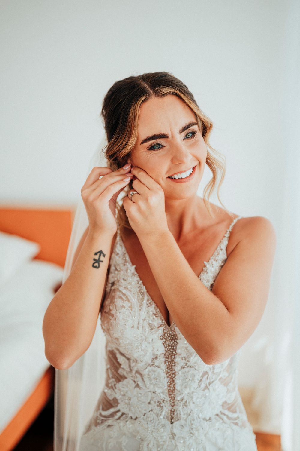Candid emotional moments of a bride in an ornate lace wedding dress against a light background.