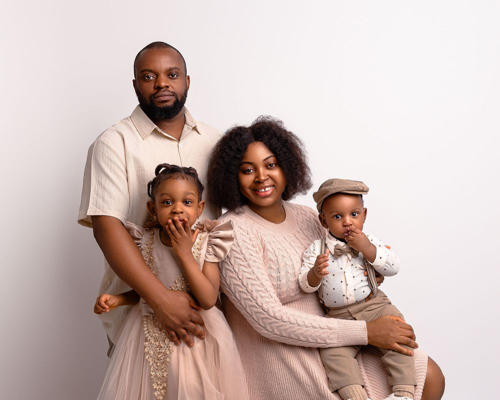 Family of four hugging and laughing during studio photo session in Wolverhampton