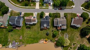 Overhead view of a residential neighborhood with houses, streets, and green spaces.