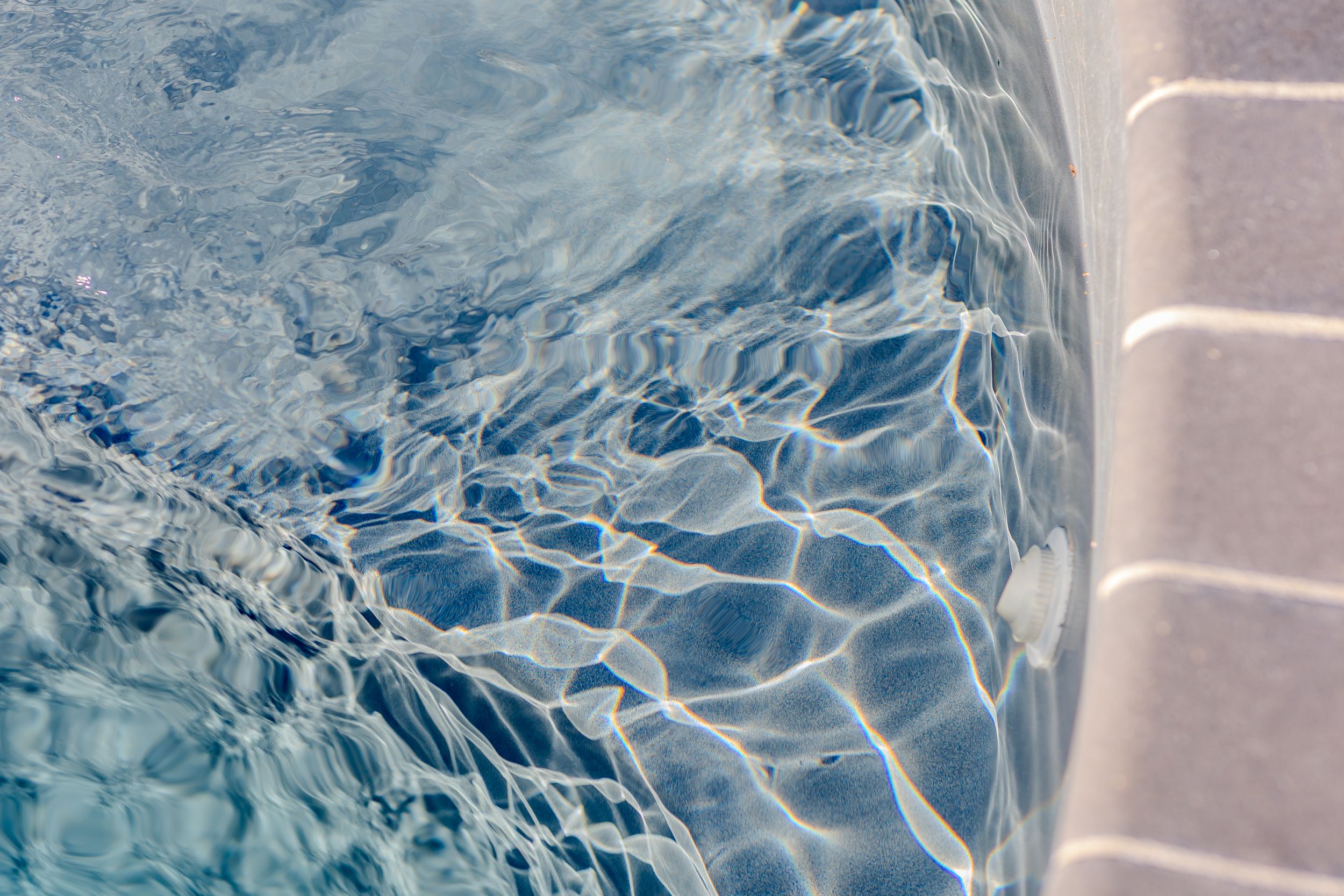 Close-up view of rippling water with light reflections creating abstract patterns.