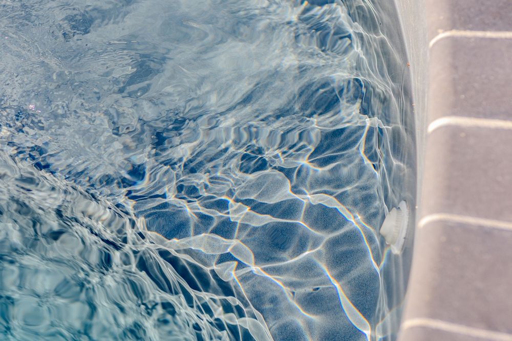 Close-up view of rippling water with light reflections creating abstract patterns.