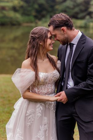 Romantic couple moment captured in soft lighting with flowing blush wedding gown.
