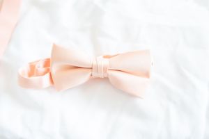 Delicate pink silk ribbons and bows arranged in a soft, romantic pattern.