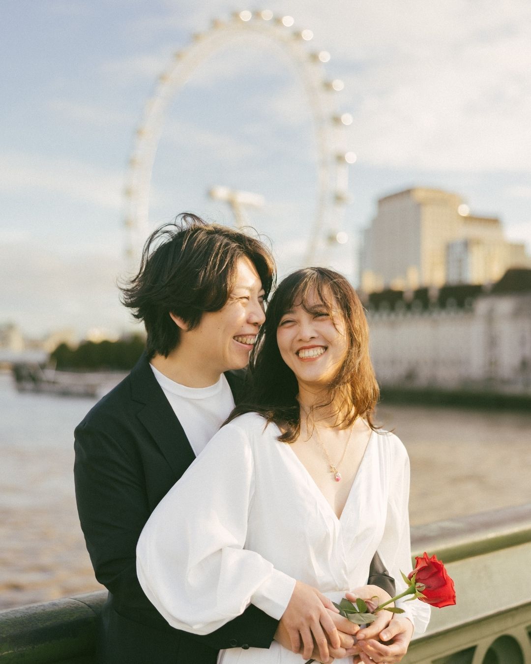 Candid romantic moments of a couple by the London Eye, beautifully captured by a destination wedding photographer in Mumbai.