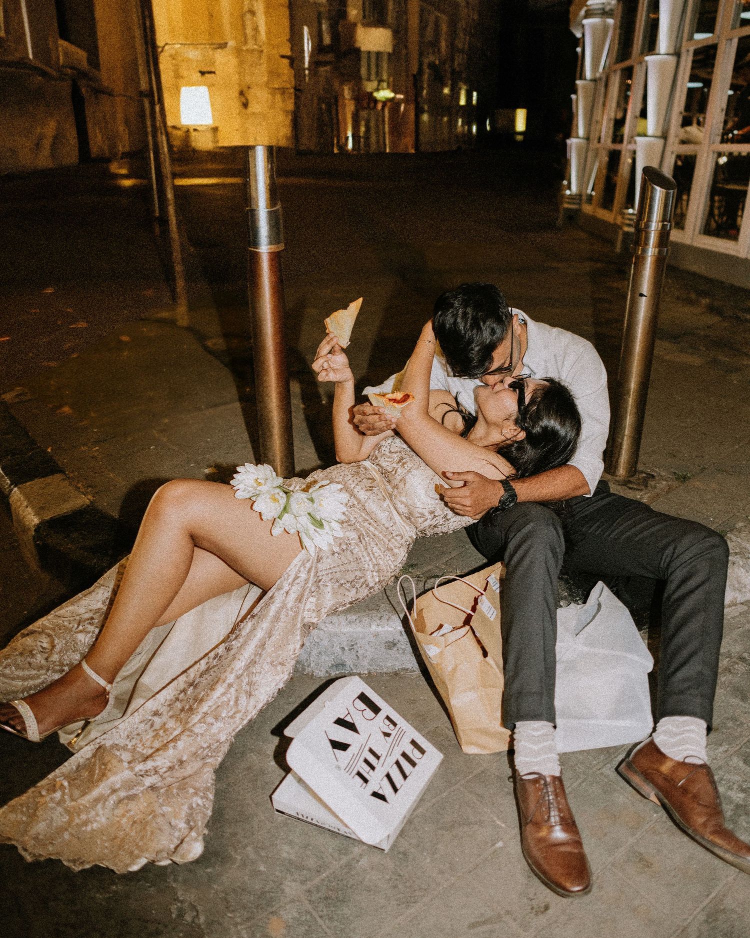 Couple playfully posing on the ground in formal wedding attire, creatively captured by a professional wedding photographer in Mumbai.