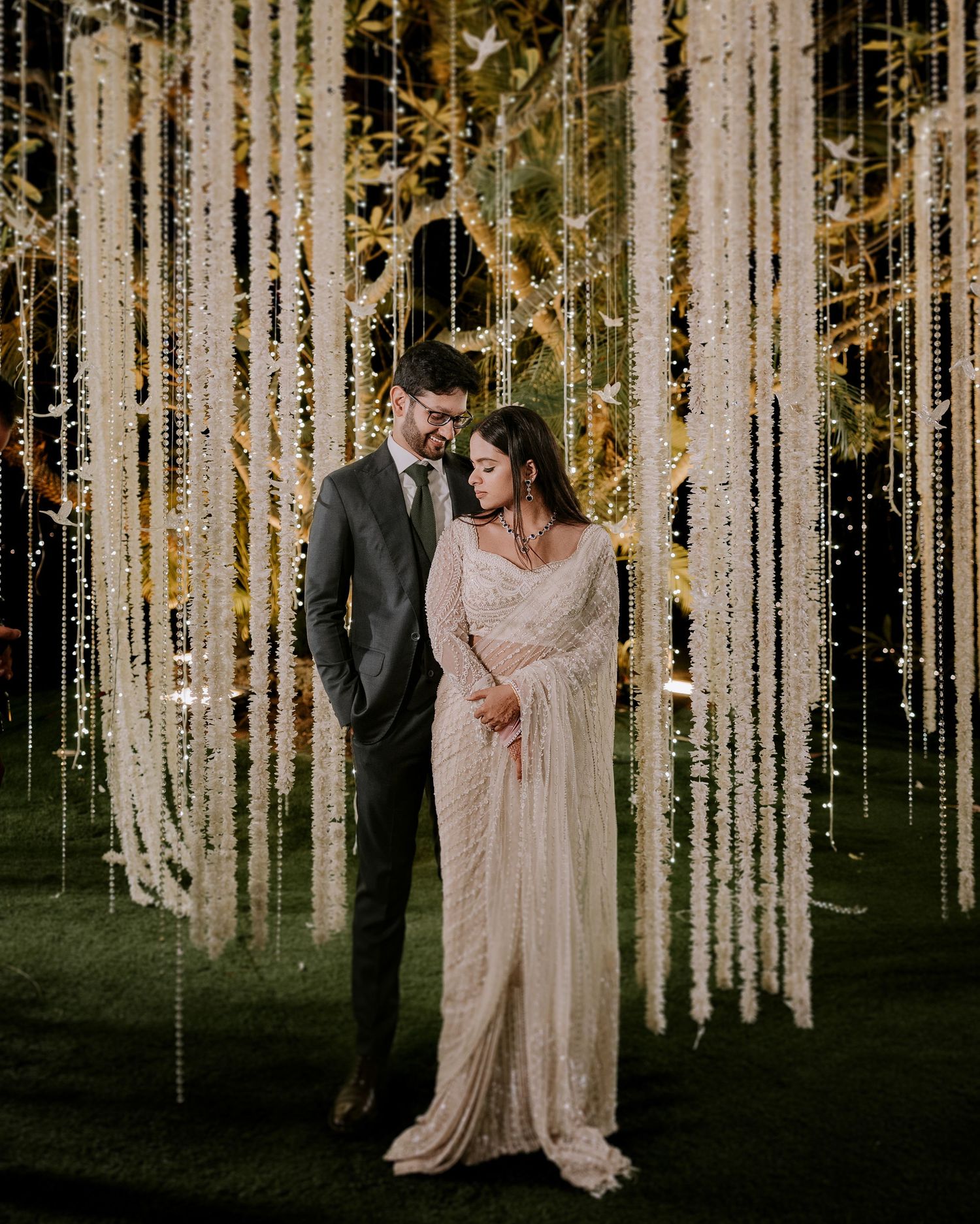 Looking for a wedding photographer In Mumbai? Romantic couple under cascading white florals by Mumbai's finest wedding photographer.