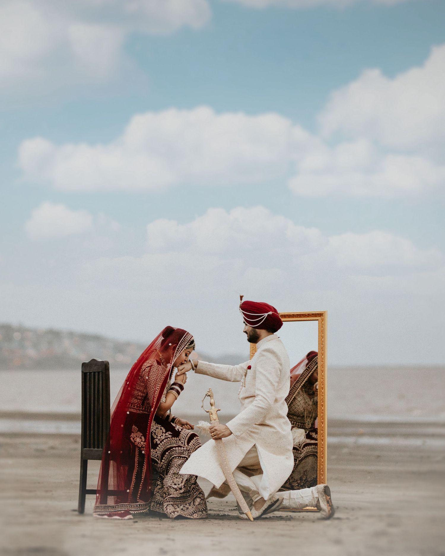 Stunning traditional attire couple beach photoshoot against blue sky, elegantly shot by a trusted wedding photographer near me in Mumbai.