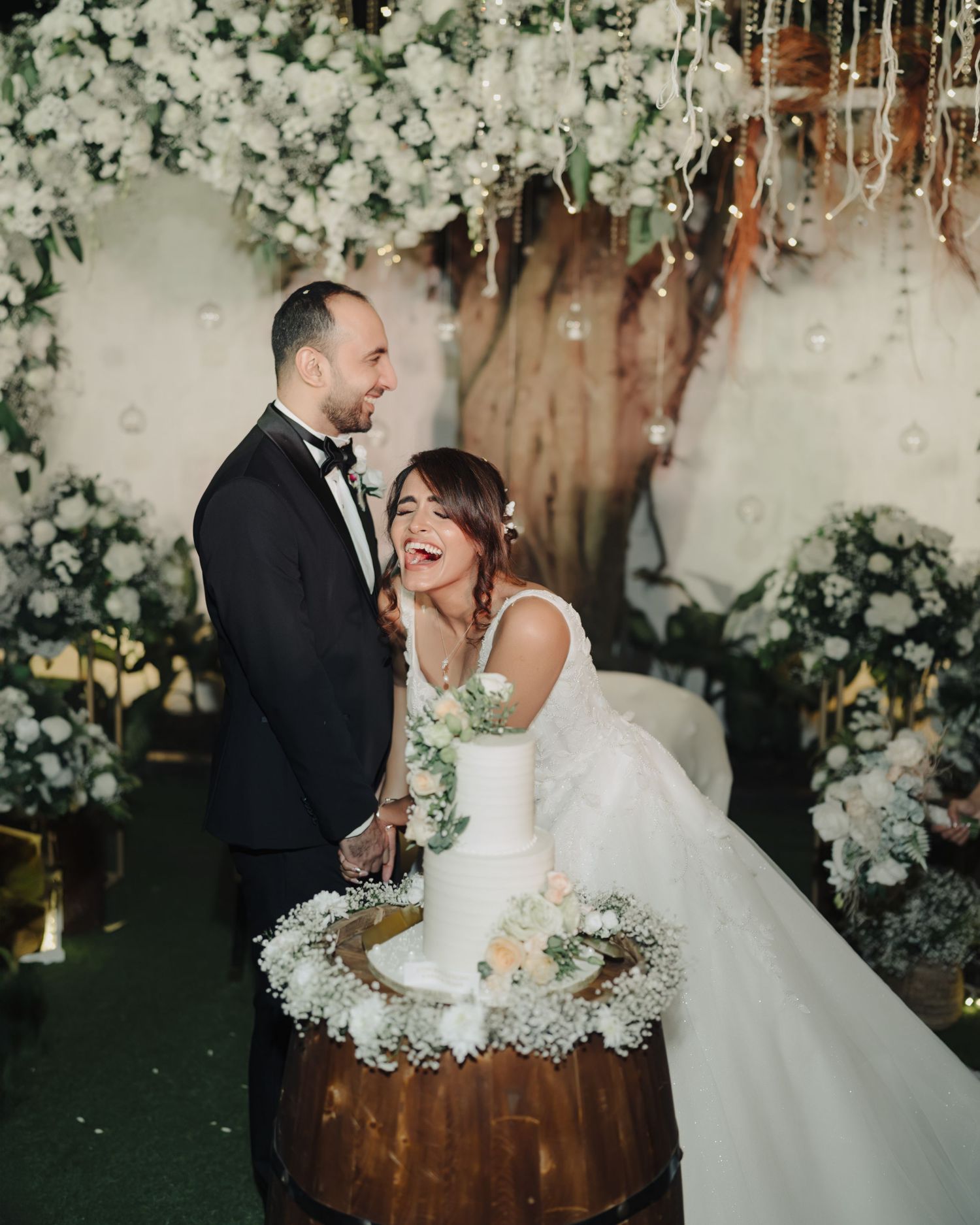 Wedding couple sharing intimate moment amid white florals, captured by wedding Photographer in Mumbai, trusted Wedding photographer near me