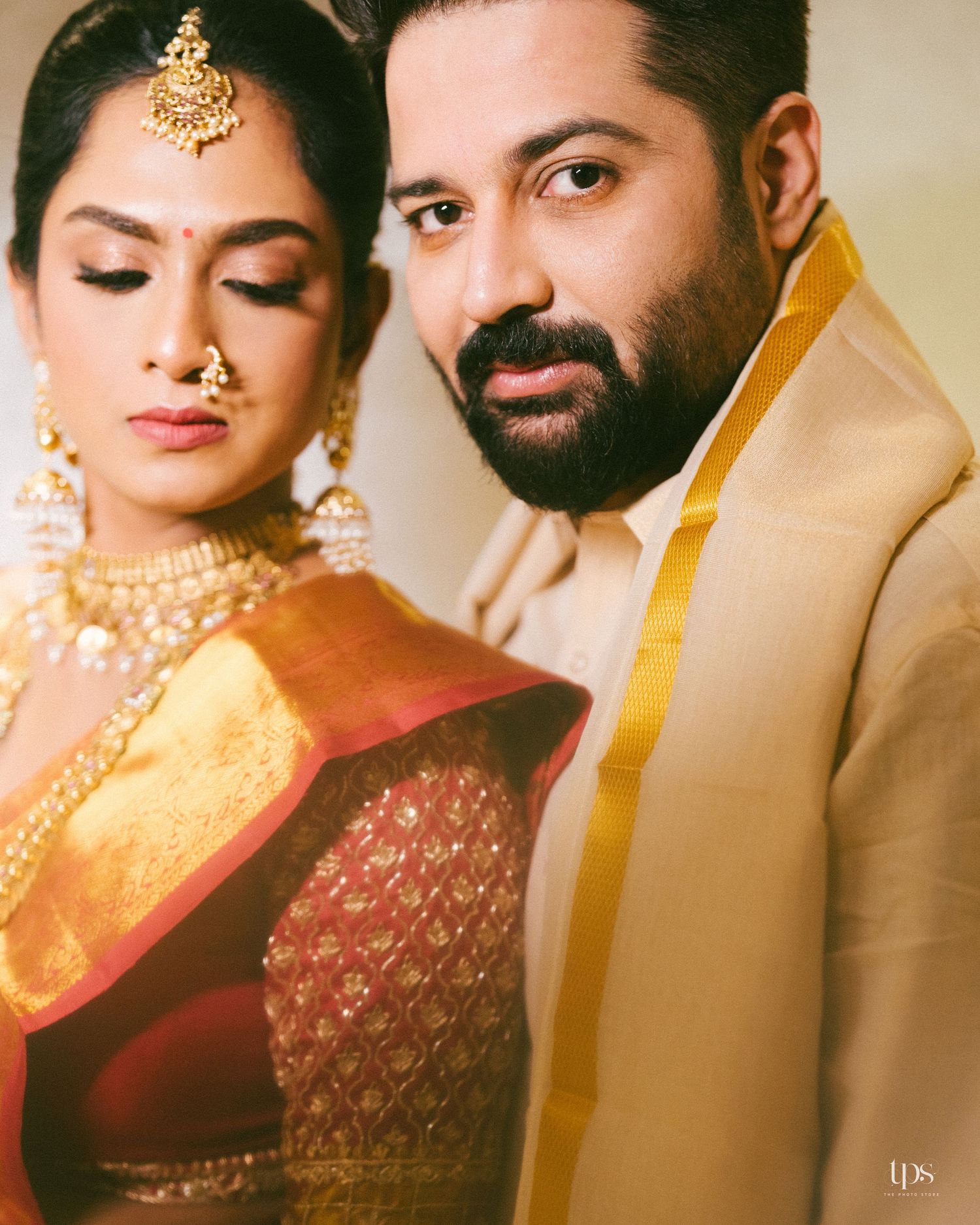 Elegant South Asian wedding portrait in gold and red outfits, shot by a wedding Photographer in Mumbai, trusted Wedding photographer near me