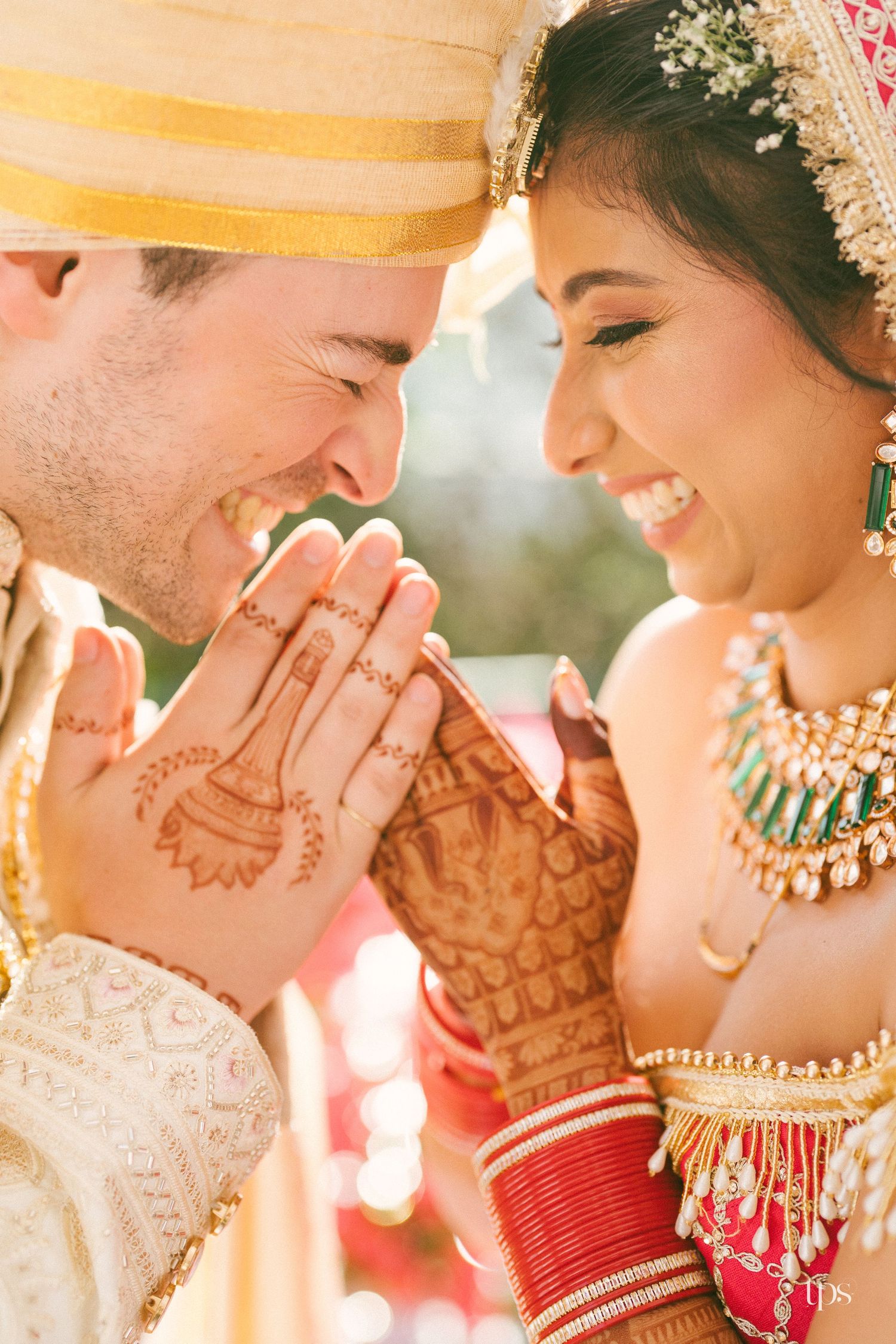 Indian bride and groom in traditional attire share a joyful mehndi moment beautifully captured by a wedding photographer in Mumbai near me.