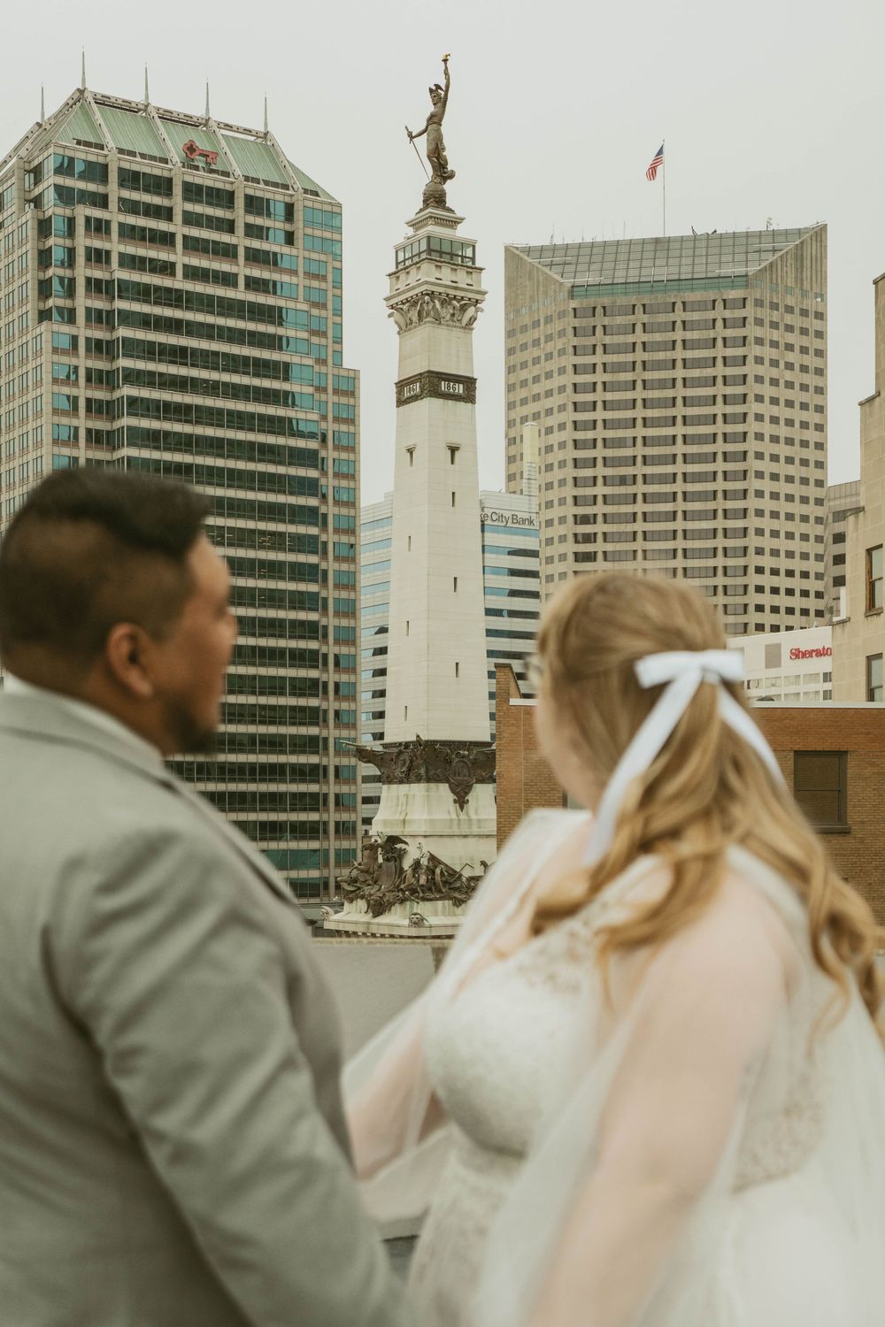 Bride and groom stand before the Soldiers and Sailors Monument in downtown Indianapolis during their wedding.