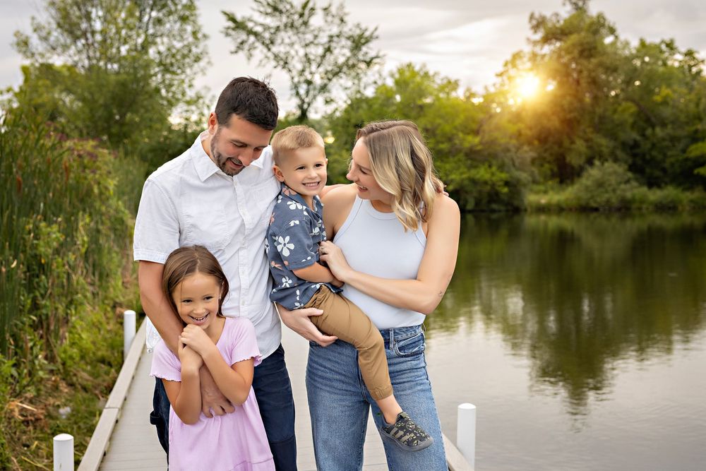 Family photo session at sunset by a serene lake with candid shots showing loving moments and laughter.  family photography Delafield WI