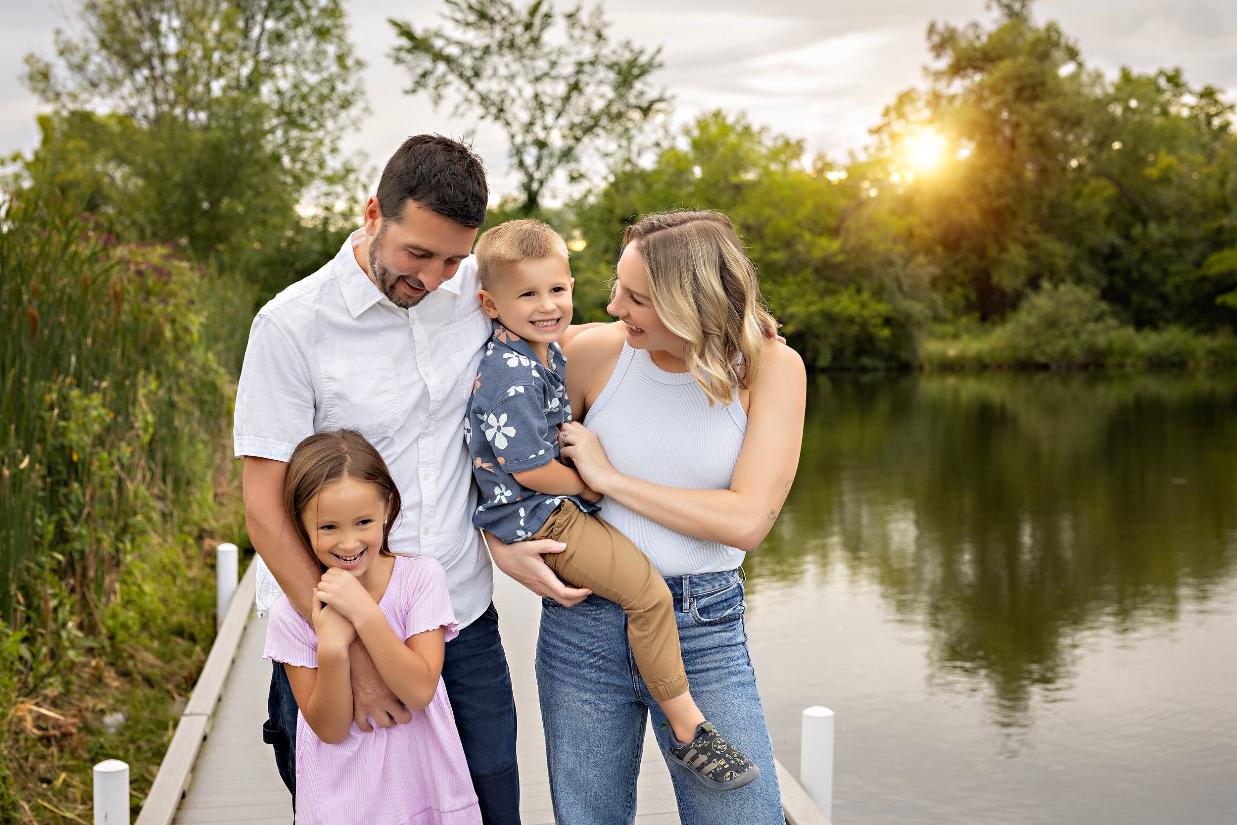 Family photo session at sunset by a serene lake with candid shots showing loving moments and laughter.  family photography Delafield WI