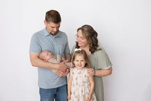 Family laughs together during candid portrait session in light and airy studio setting.  Kendall Kuss Photography Watertown WI