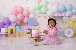 first birthday cake smash setup featuring soft pink, purple, mint and blue decorations.   Kendall Kuss Photography Watertown WI
